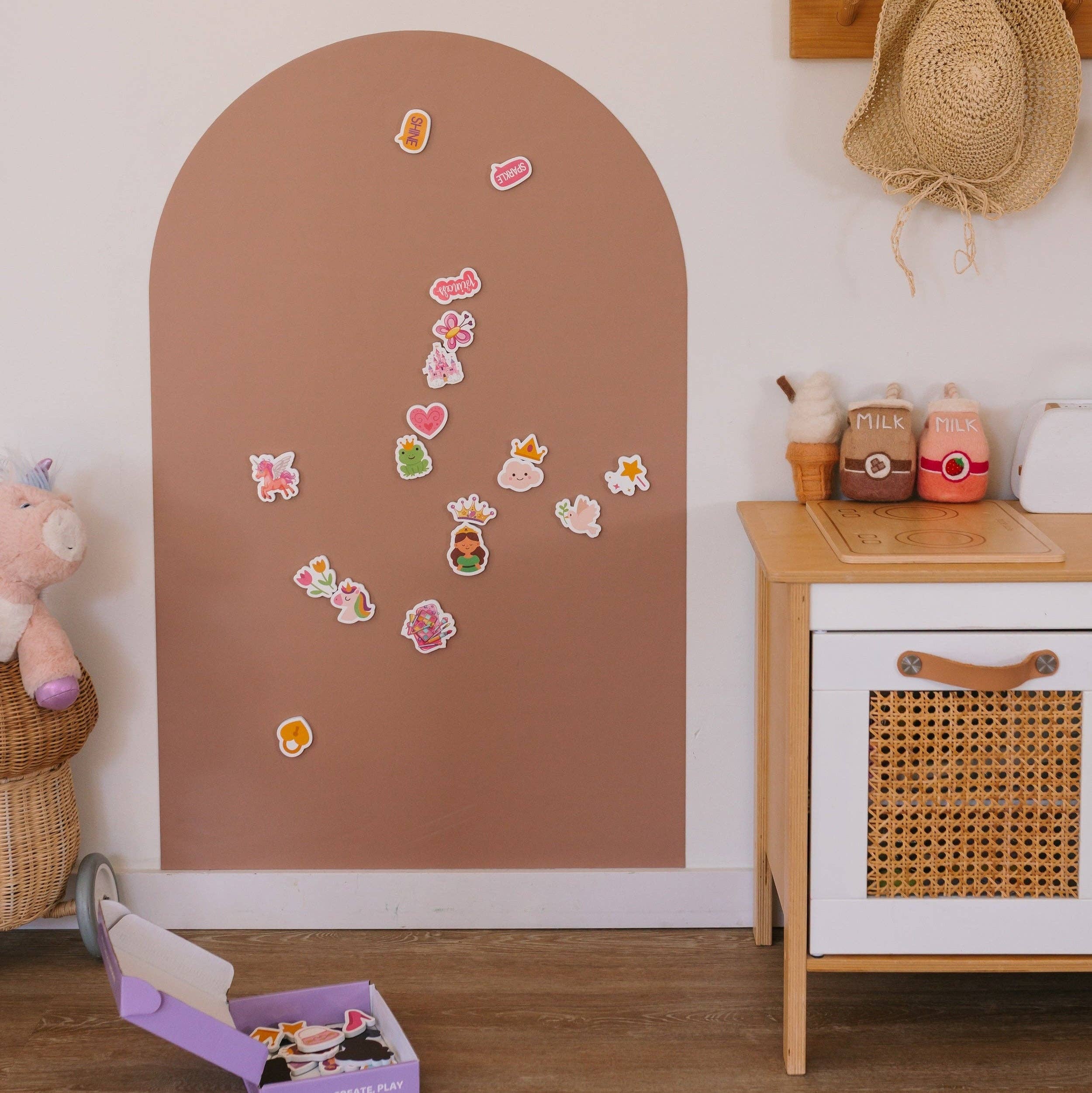 Children's room with a brown arch-shaped wall, decorative stickers, and wooden furniture.