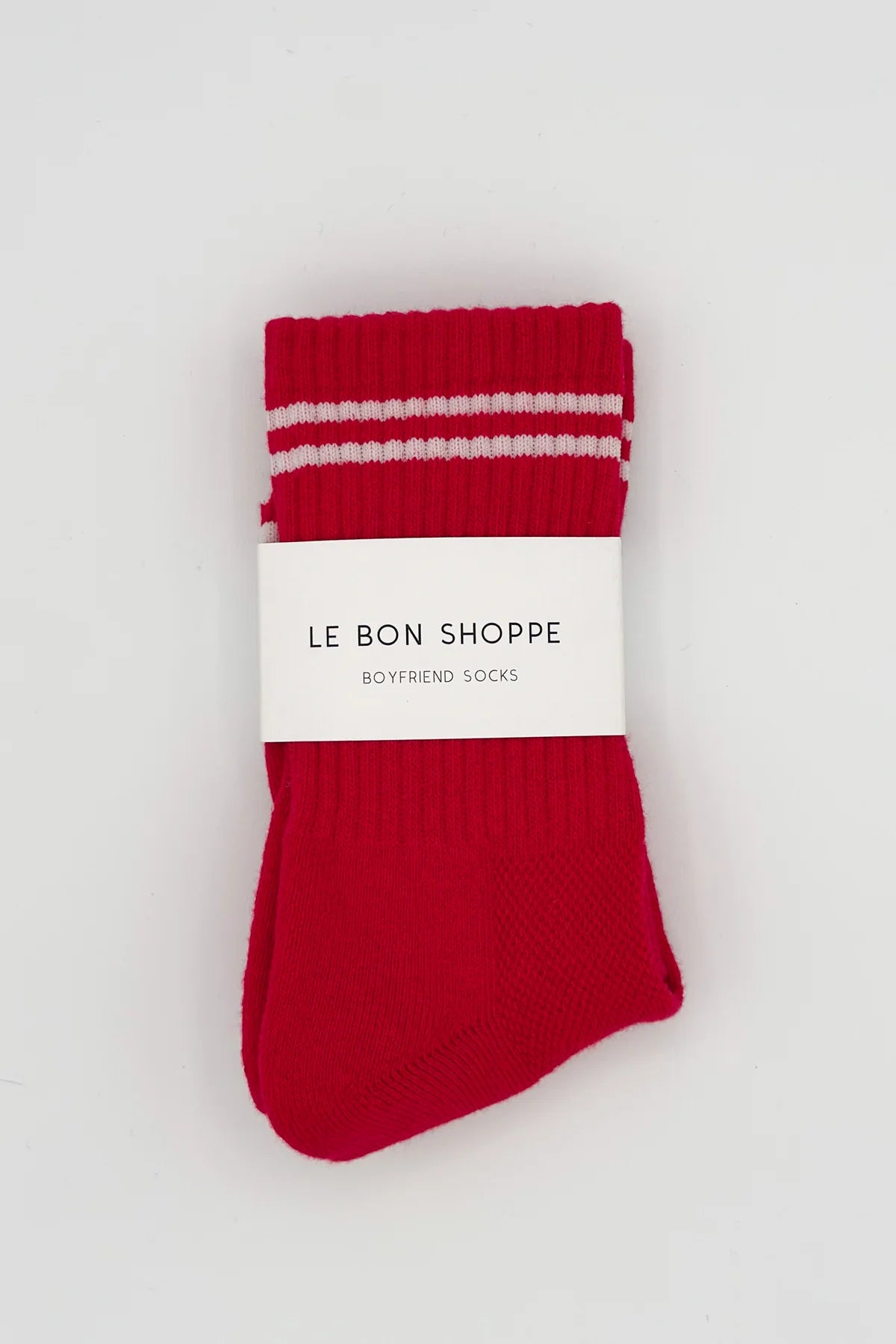 Red socks with white stripes on a white background, featuring 'Le Bon Shoppe' branding.