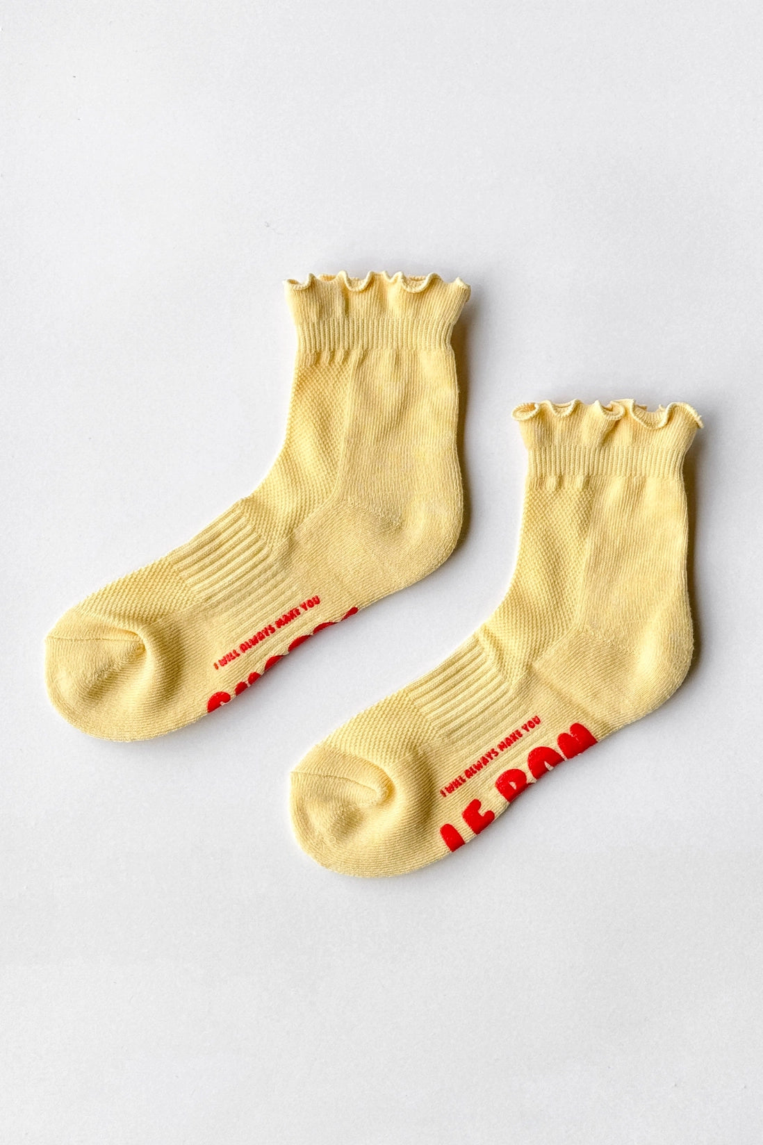 Pair of yellow socks with red text on a light gray background