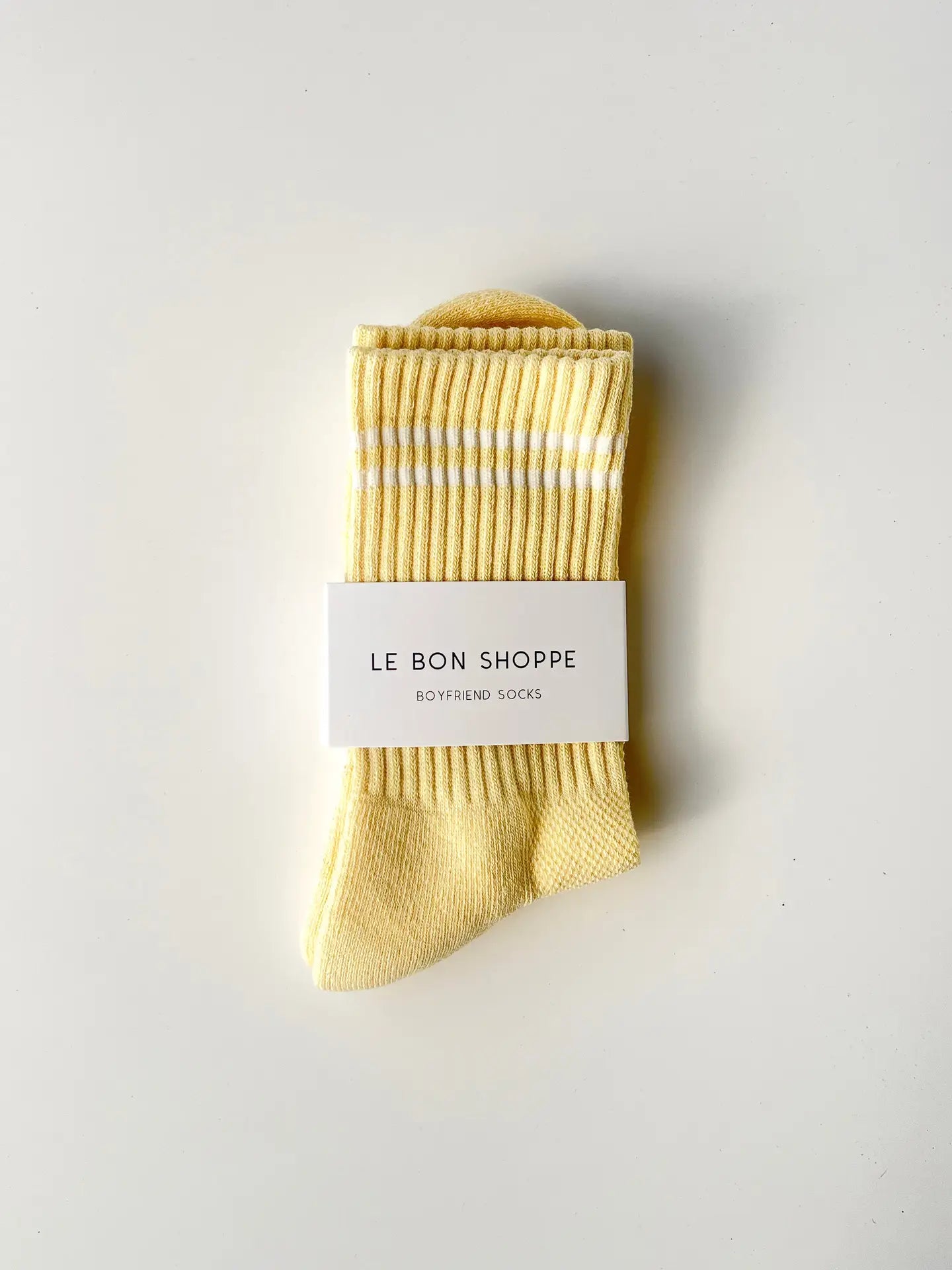 Pack of yellow socks with a white label on a light gray background
