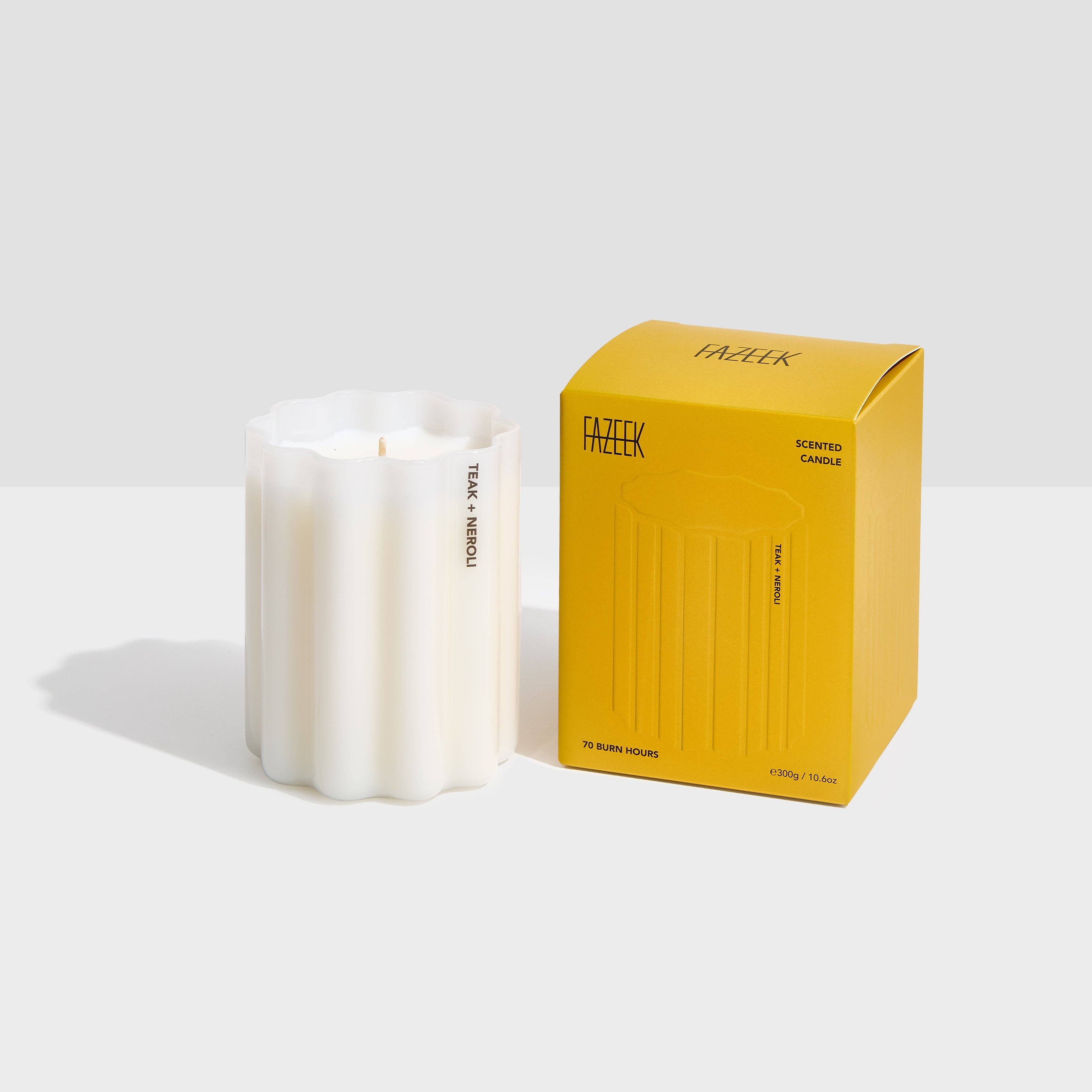 White candle next to a yellow Fazeek box on a white background