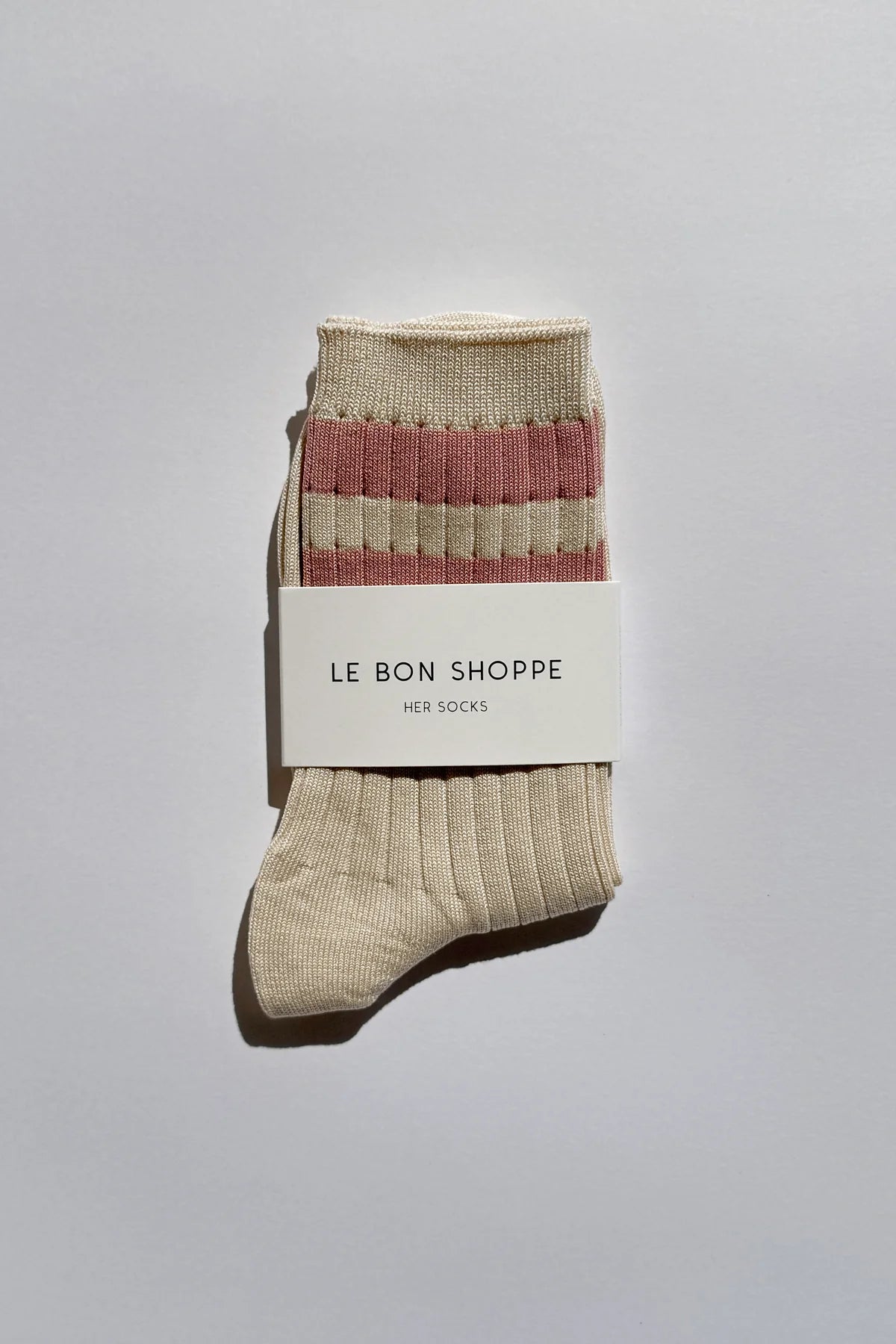 Beige sock with red stripes on a white label against a gray background