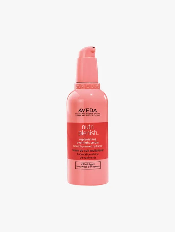 A bottle of Aveda Nutri Plenus Replenishing Overnight Serum in a vibrant pink color, shown against a plain light gray background.