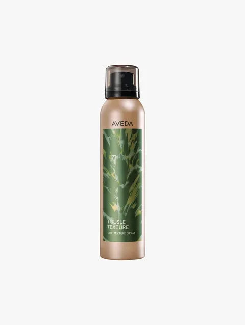 Aveva Triple Texture Dry Shampoo in a metallic beige spray bottle with a green leaf label and black cap, centered on a light gray background.