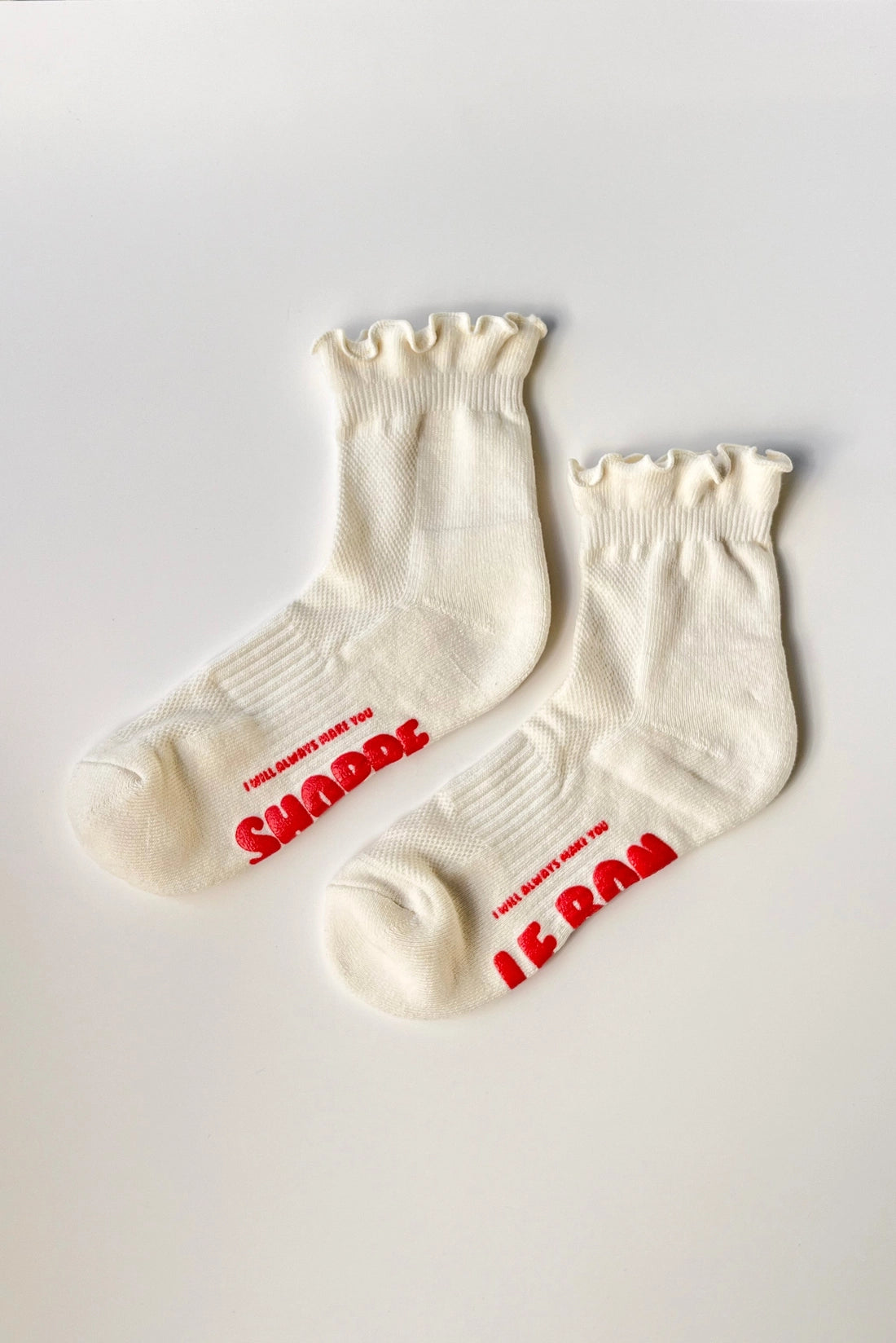 Pair of white socks with red text on a light gray background