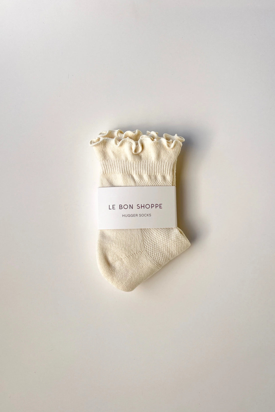 Beige sock with ruffled top on a white background, featuring 'Le Bon Shoppe' label.