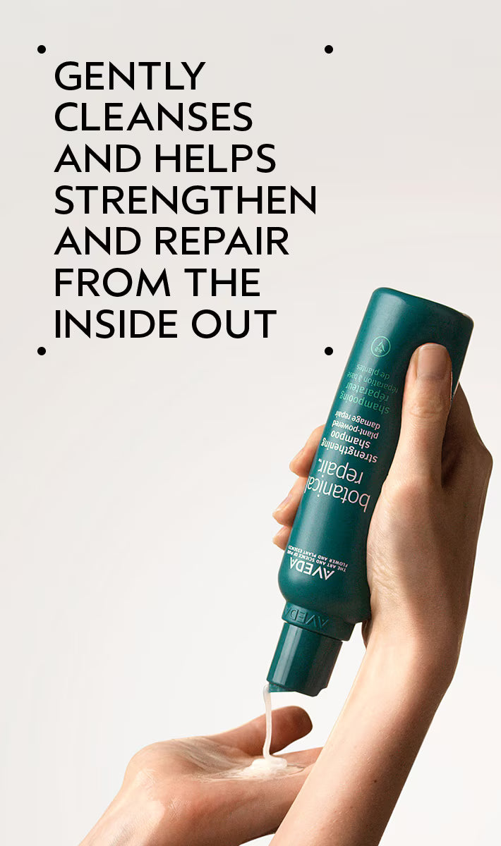 Hand holding a green bottle of Aveeno skin relief lotion with text on a light gray background