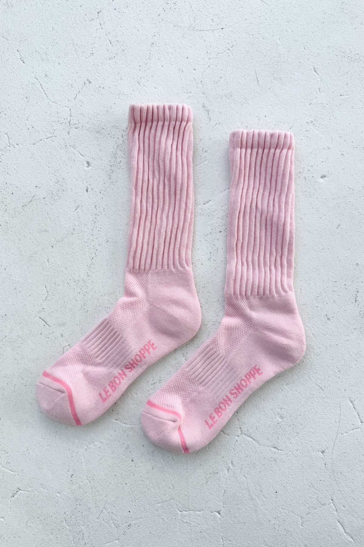 Pair of pink socks with text on a light gray background