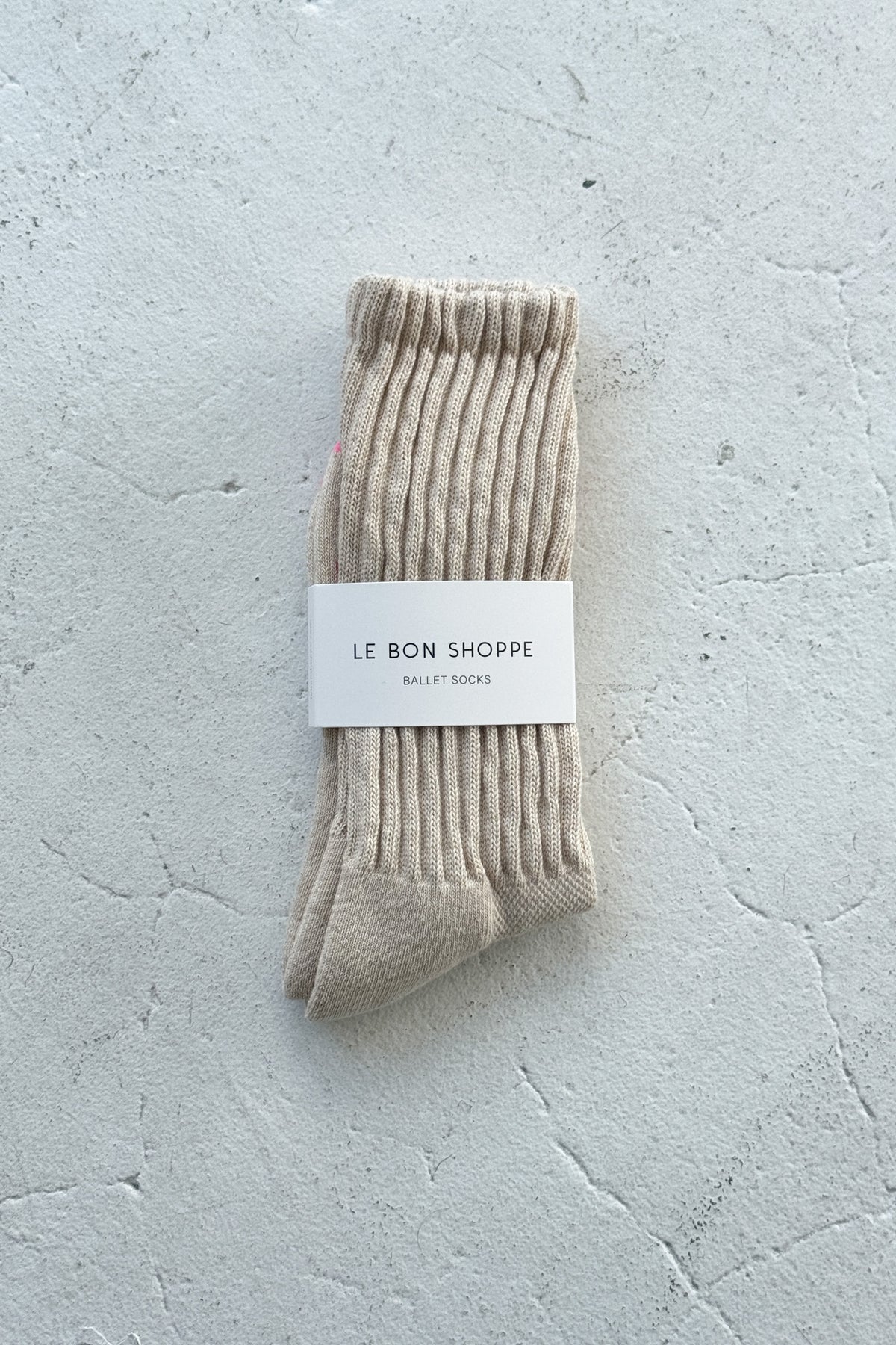 Beige sock with a label on a light gray textured background