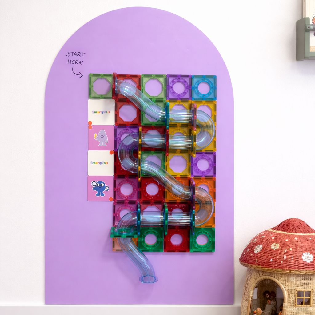 Colorful plastic maze with tunnels on a purple board, resembling a slide, with a small toy house in the corner.