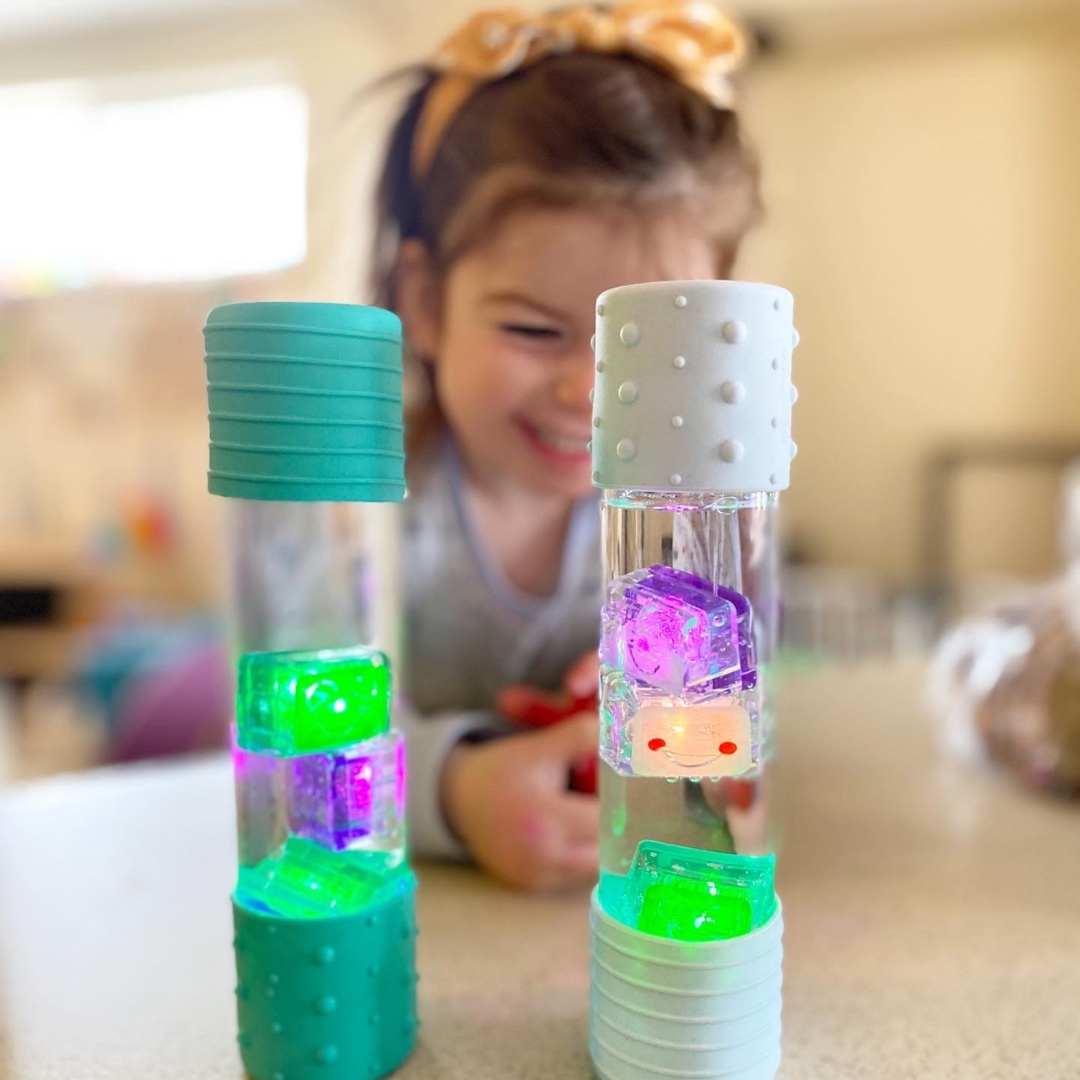 Child playing with a colorful sensory bottle