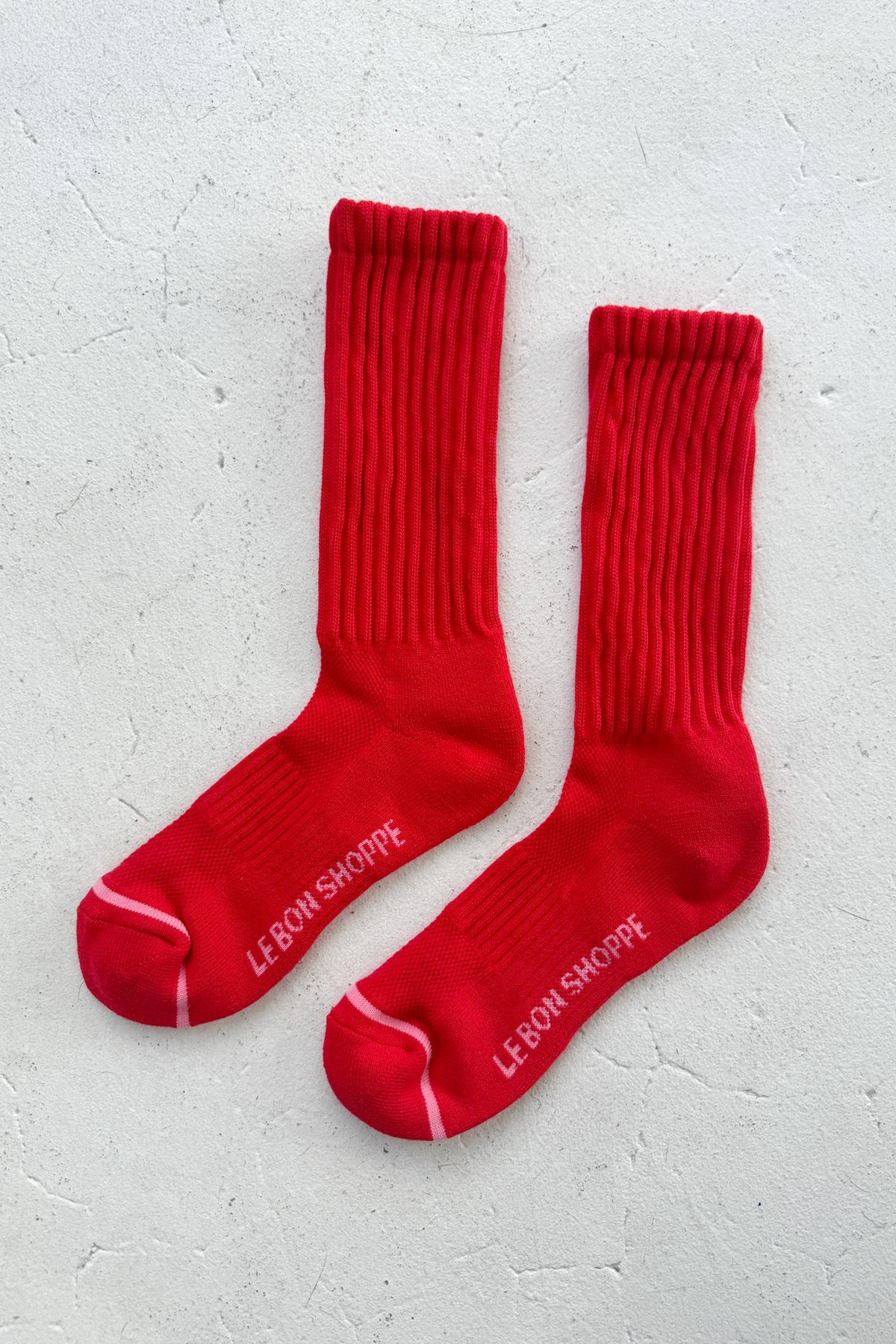 Red socks with a brand logo on a light gray background