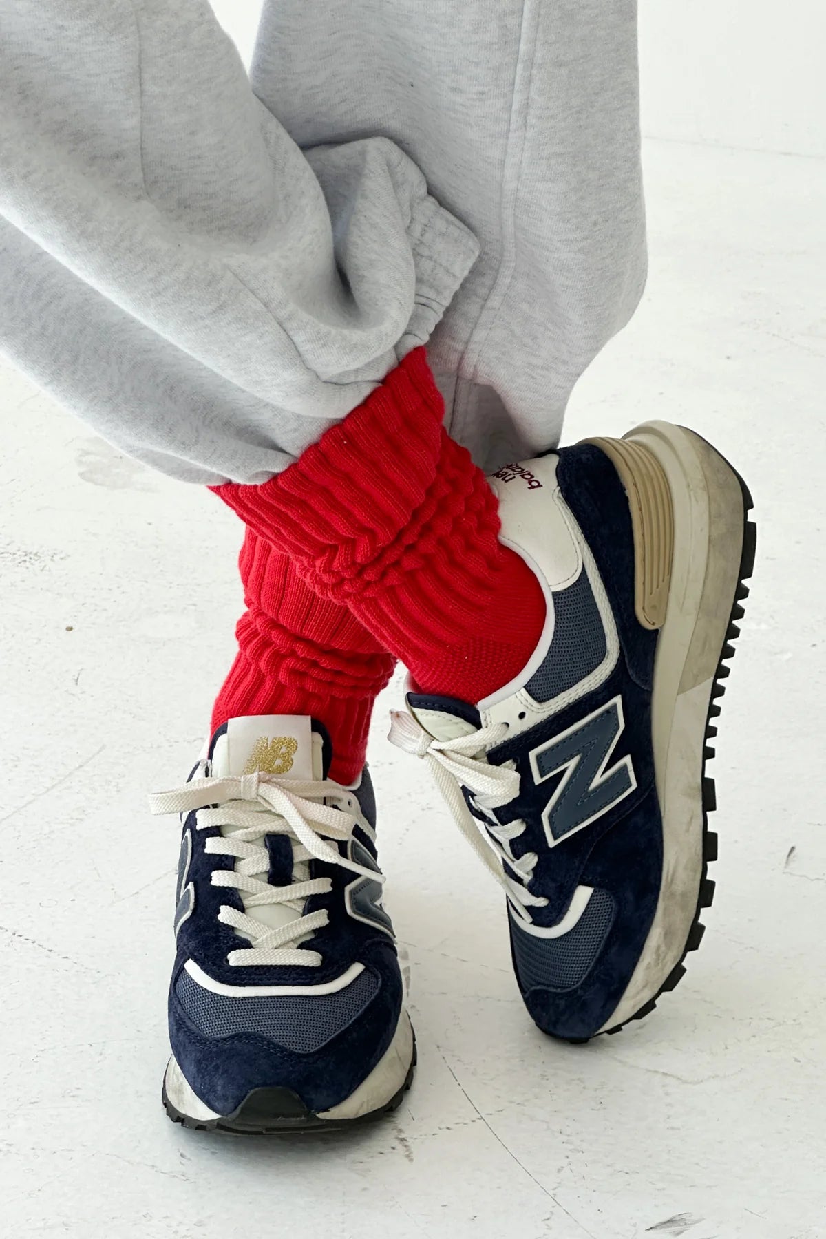 Navy and white sneakers with red socks on a light background