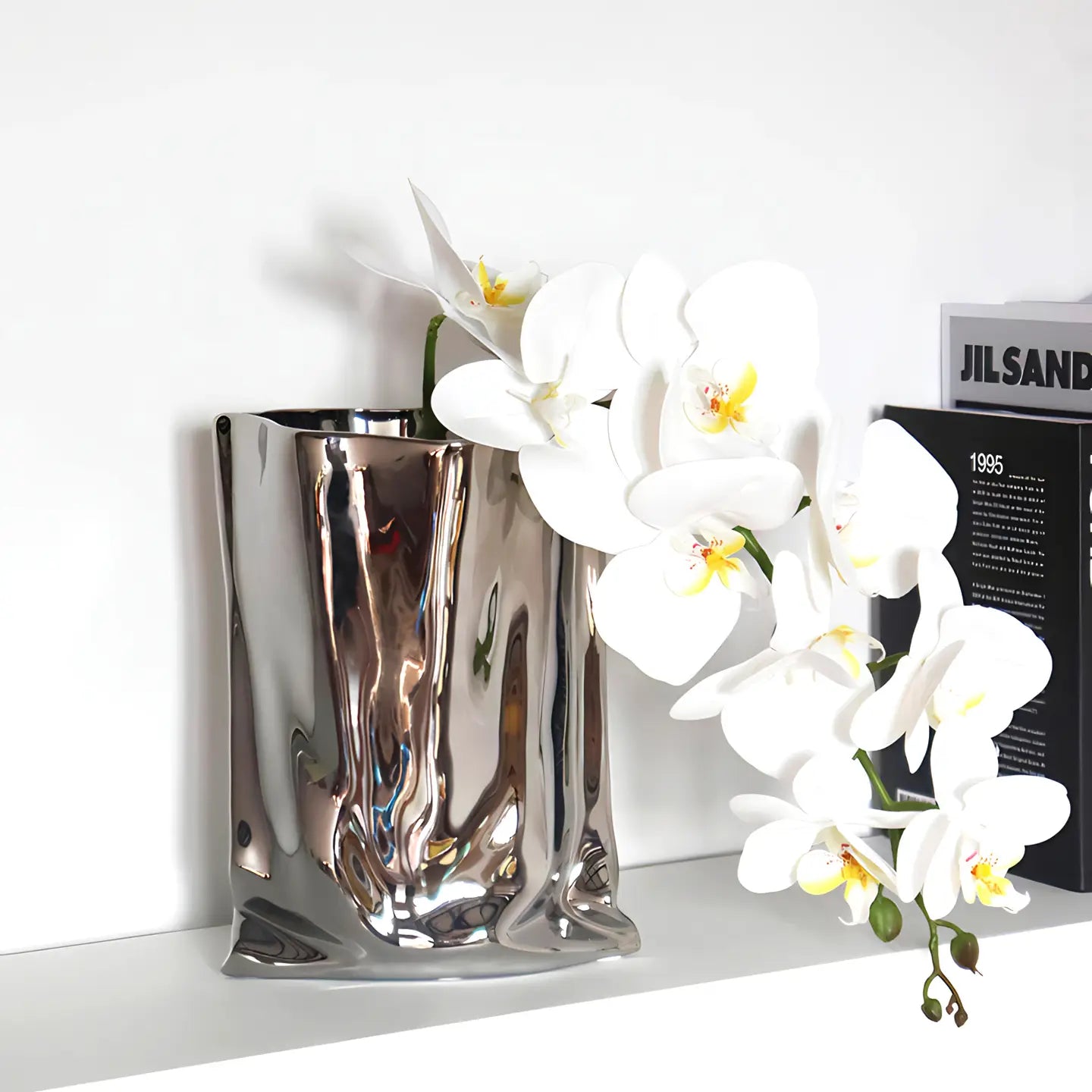 Silver vase with white orchids