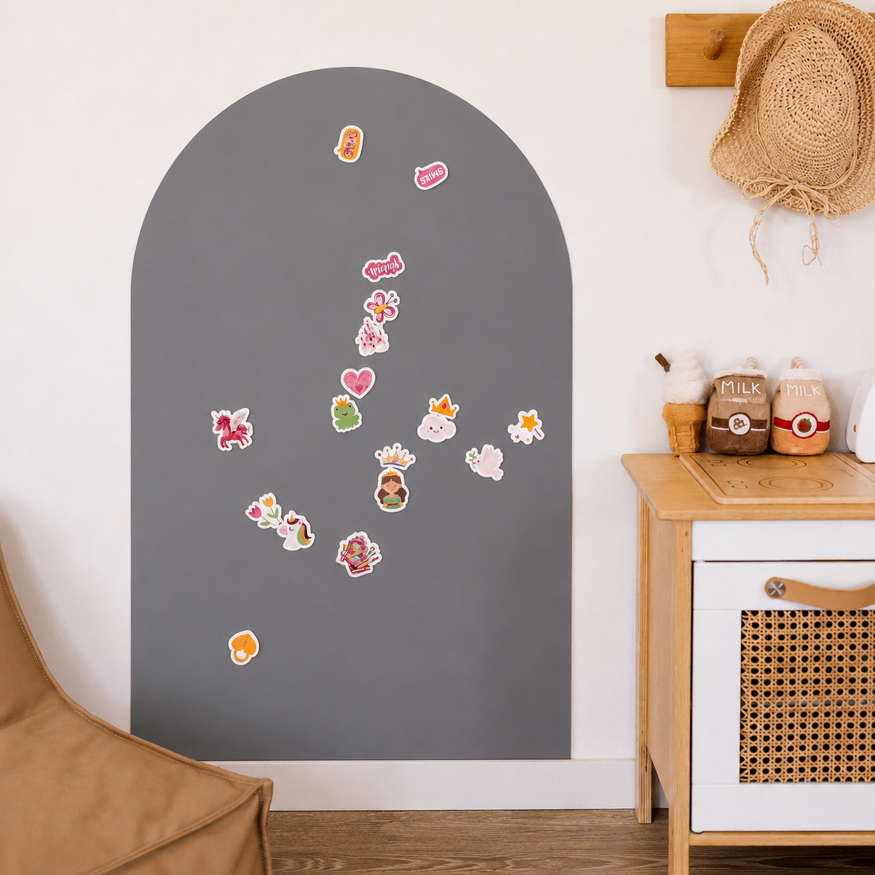Decorative stickers on a gray arch-shaped board in a room with a wooden table and chair.