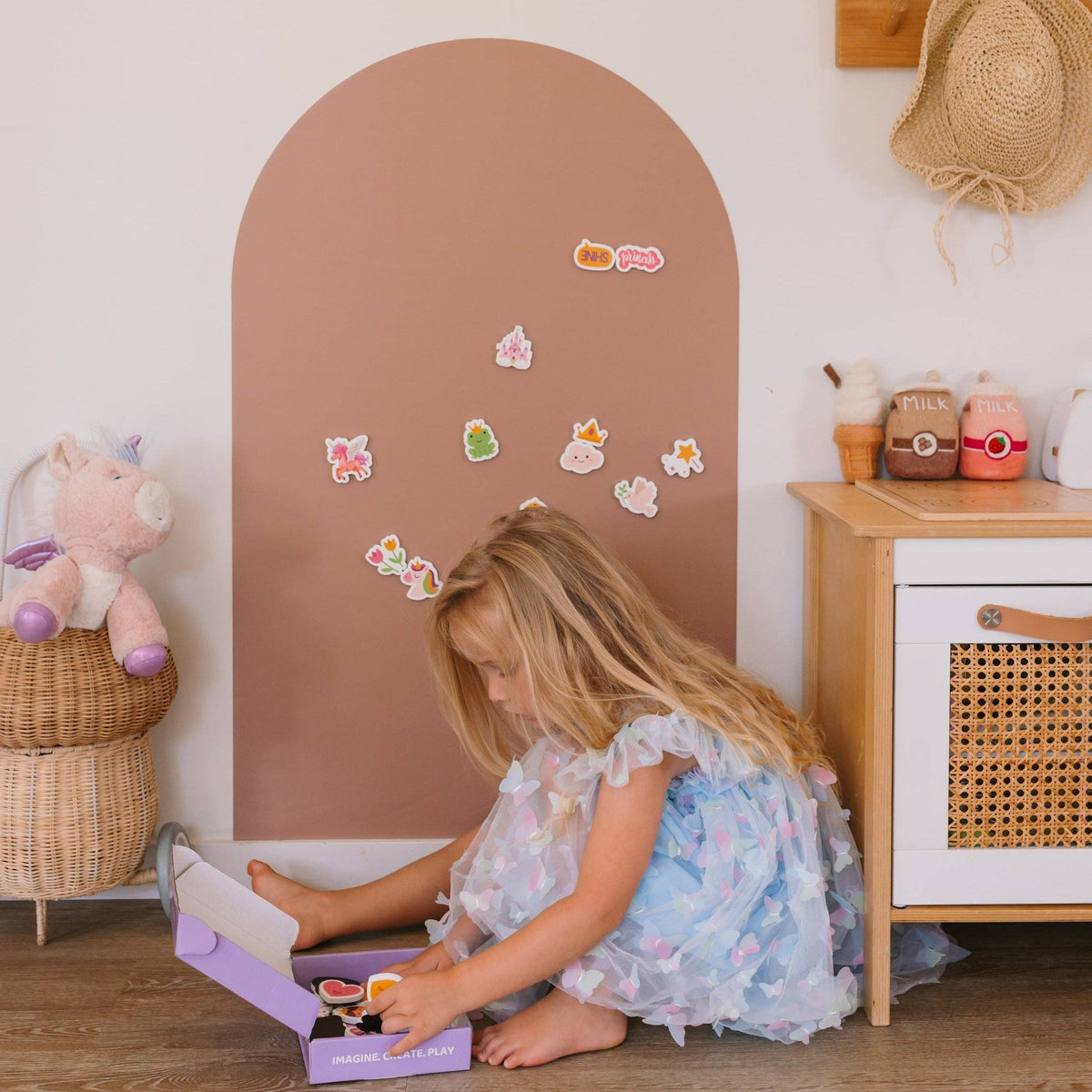 Child playing with a toy box in a room with a mirror and decorative items.