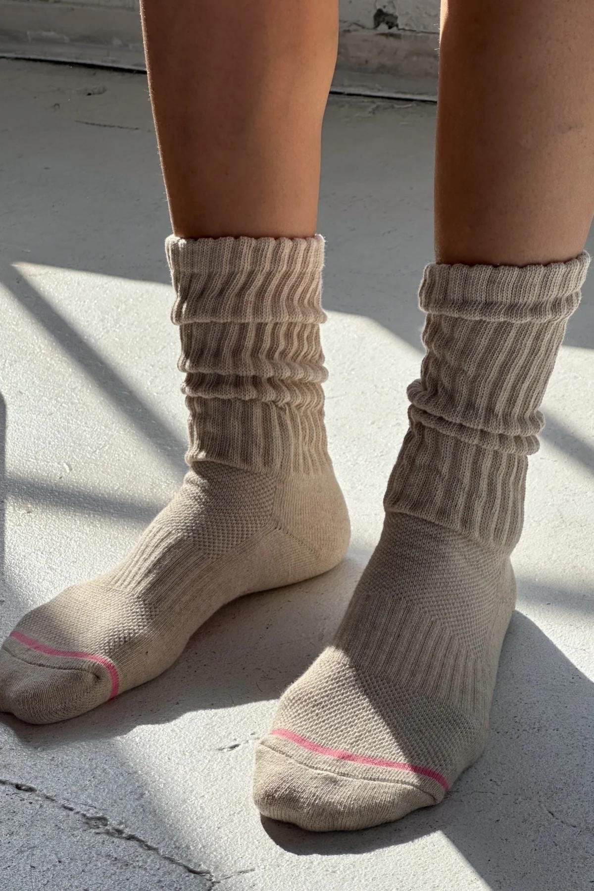 Beige socks worn by a person on a light gray surface