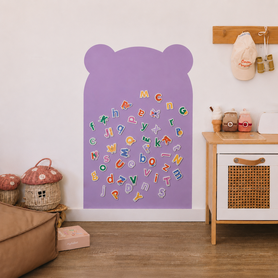 A purple bear-shaped children's wall lettering activity board with colorful alphabet letters arranged in a heart shape, shown in a styled nursery room setting.