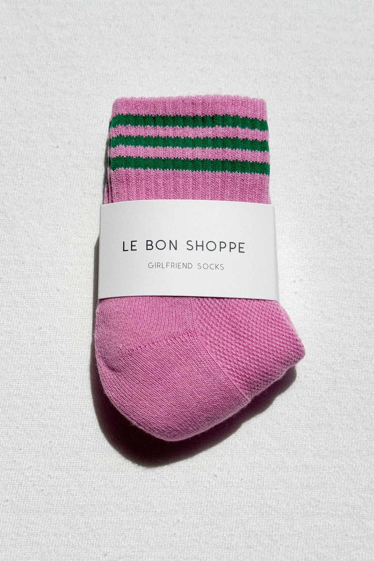 Pink socks with green stripes on a white background, featuring 'Le Bon Shoppe' label.