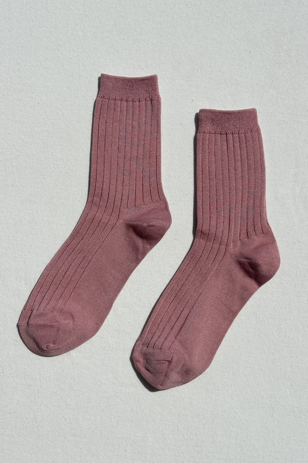 Pair of maroon socks on a light gray background