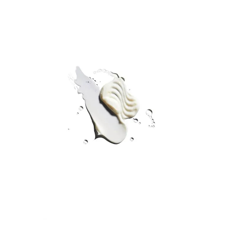 A dollop of thick, creamy off-white cosmetic product, shown with a textured swirled portion and a smoother streak, set against a solid white background.