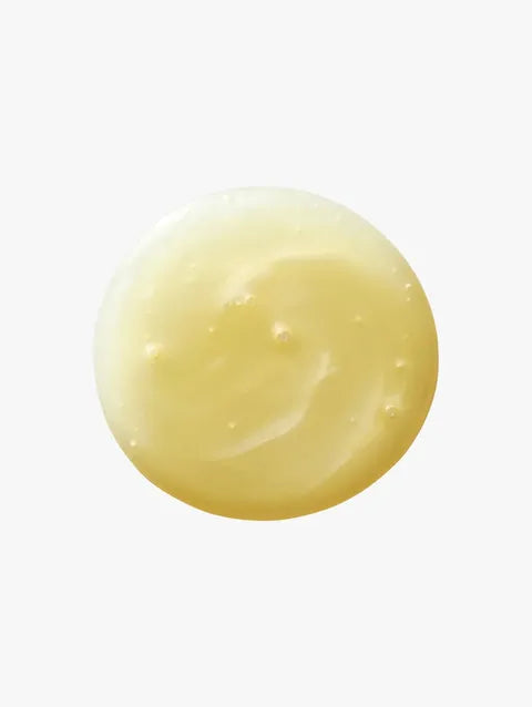A dollop of creamy, pale yellow cosmetic cream or gel on a solid white background.