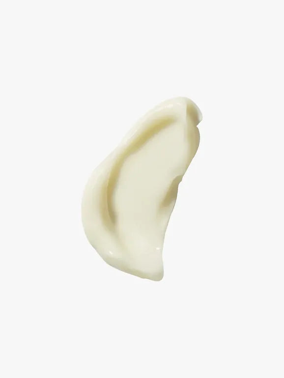 A dollop of creamy off-white cosmetic product, likely a cream or lotion, shown on a plain light gray background.