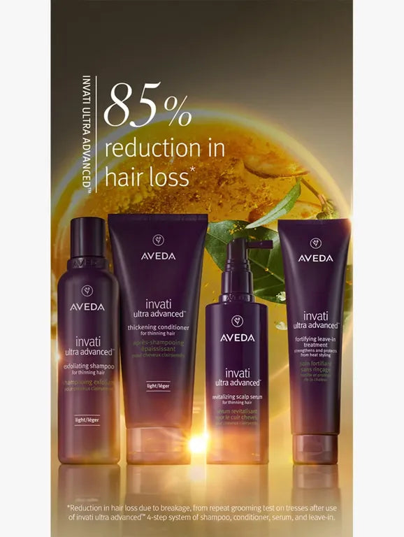 Four Aveda Invati Ultra Advanced hair care products arranged against a dark golden background with text claiming 85% reduction in hair loss.