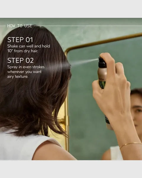 A person with shoulder-length dark brown hair sprays their hair using a small aerosol hair product in front of a mirror. White text on the left reads 'HOW TO USE' with steps 01 and 02.