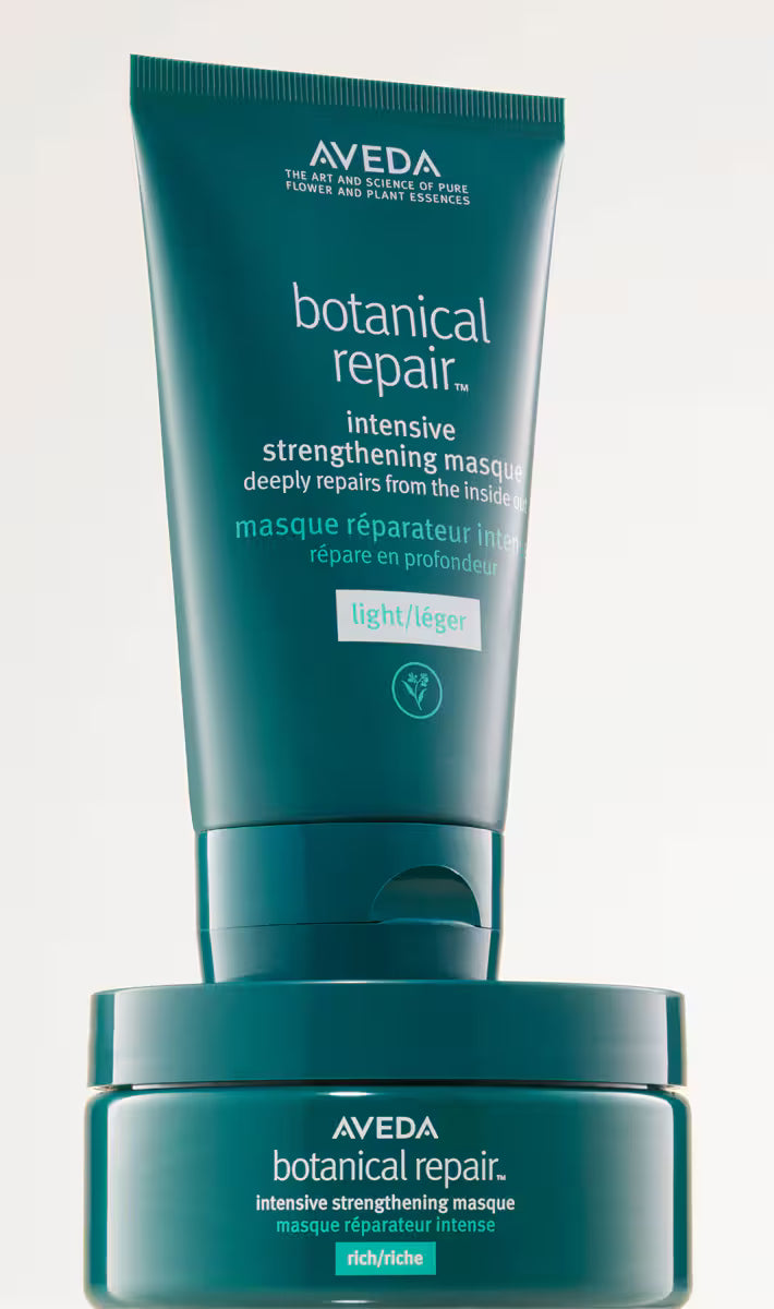 A tube and jar set of Aveda Botanical Repair Intensive Strengthening Masque, shown on a clean white background. The packaging is a deep teal color with white text and a small light green 'light' label.