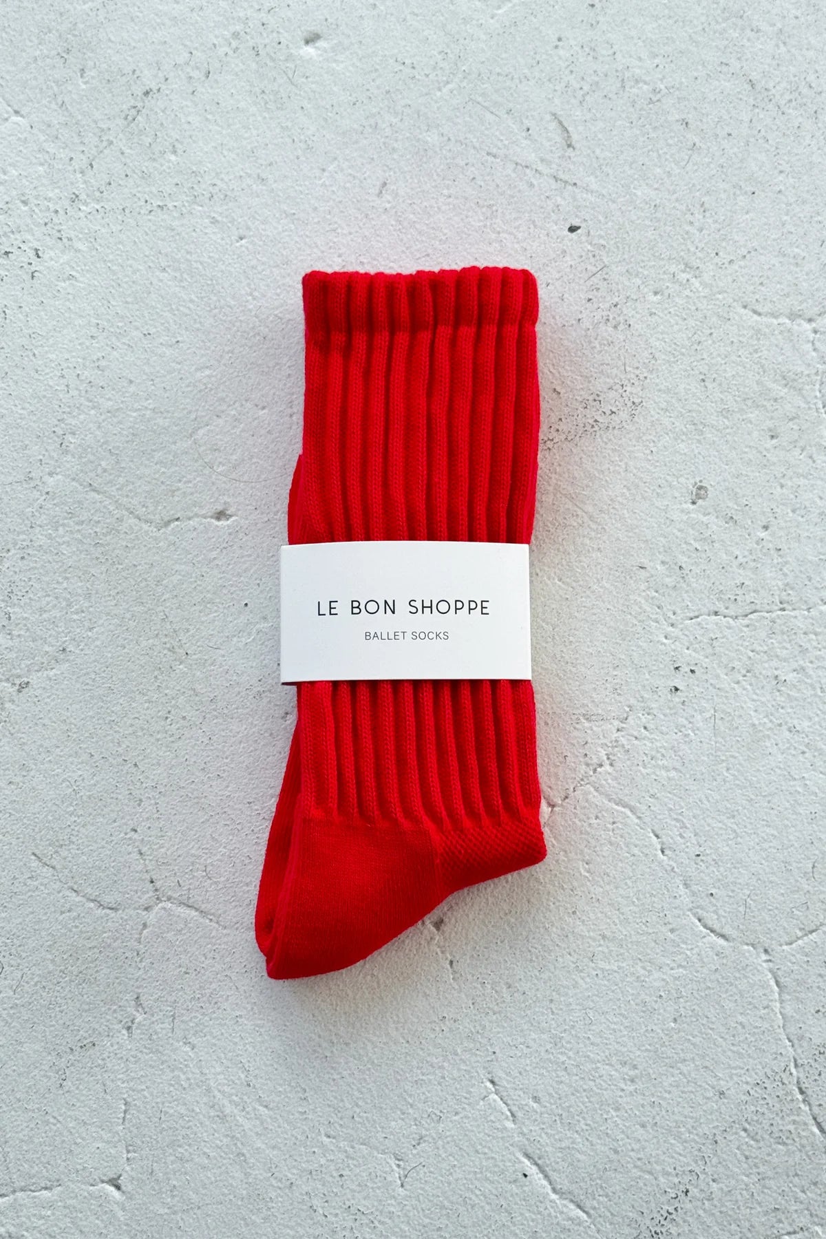 Red socks with a white label on a light gray background