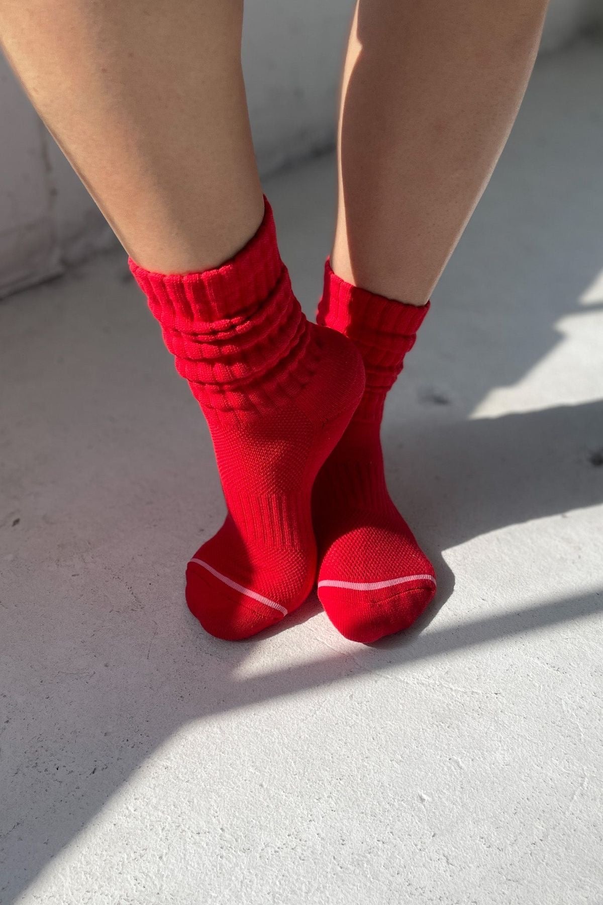 Red socks worn on feet against a light background