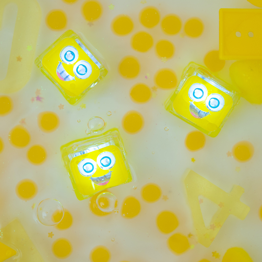 Three yellow cube-shaped toys with cartoon faces on a yellow and white background