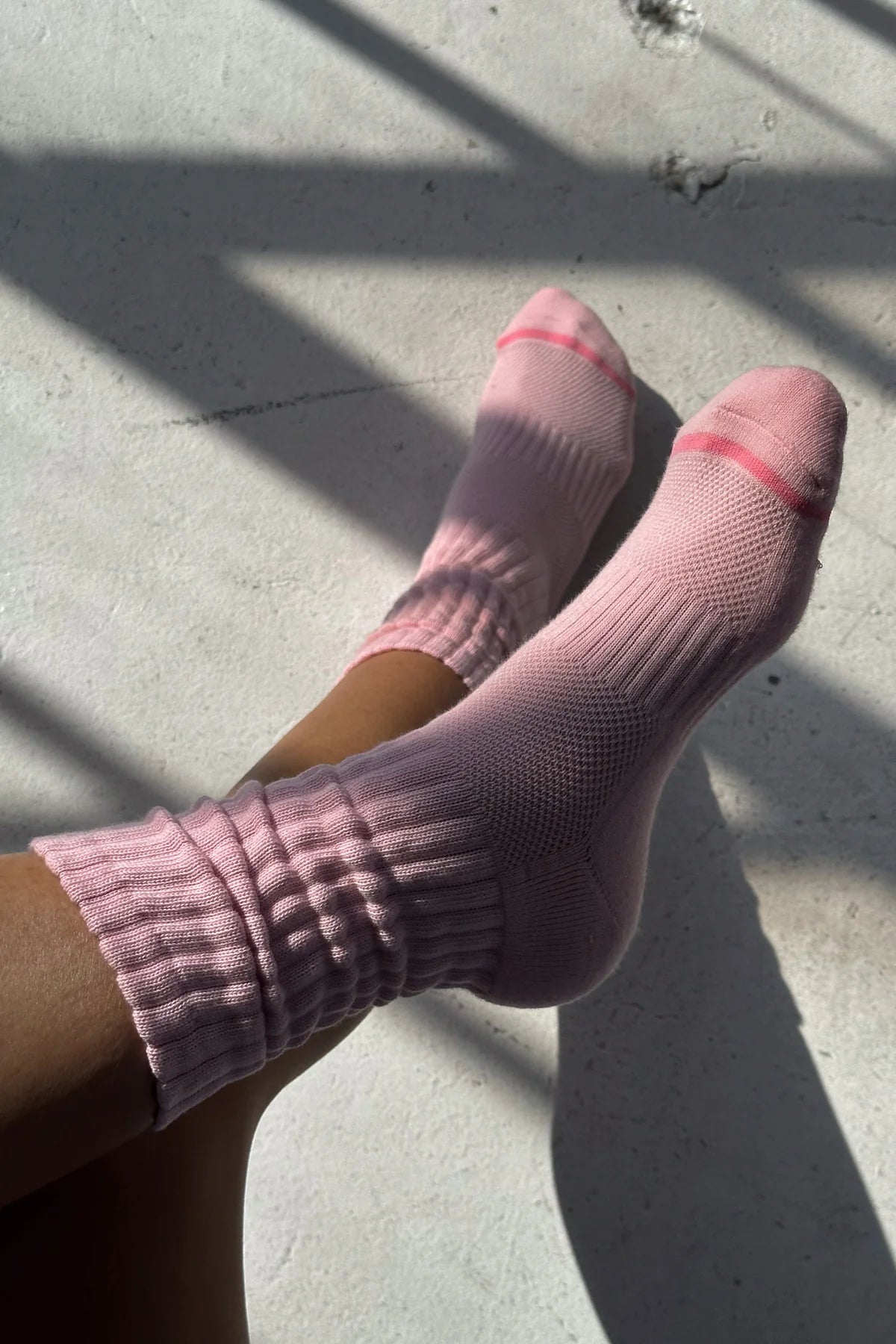 Pink socks worn on a concrete surface